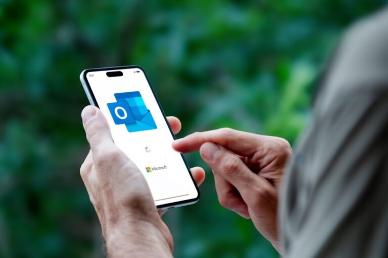 Main d’un salarié consultant sa messagerie professionnelle sur smartphone pendant un arrêt maladie