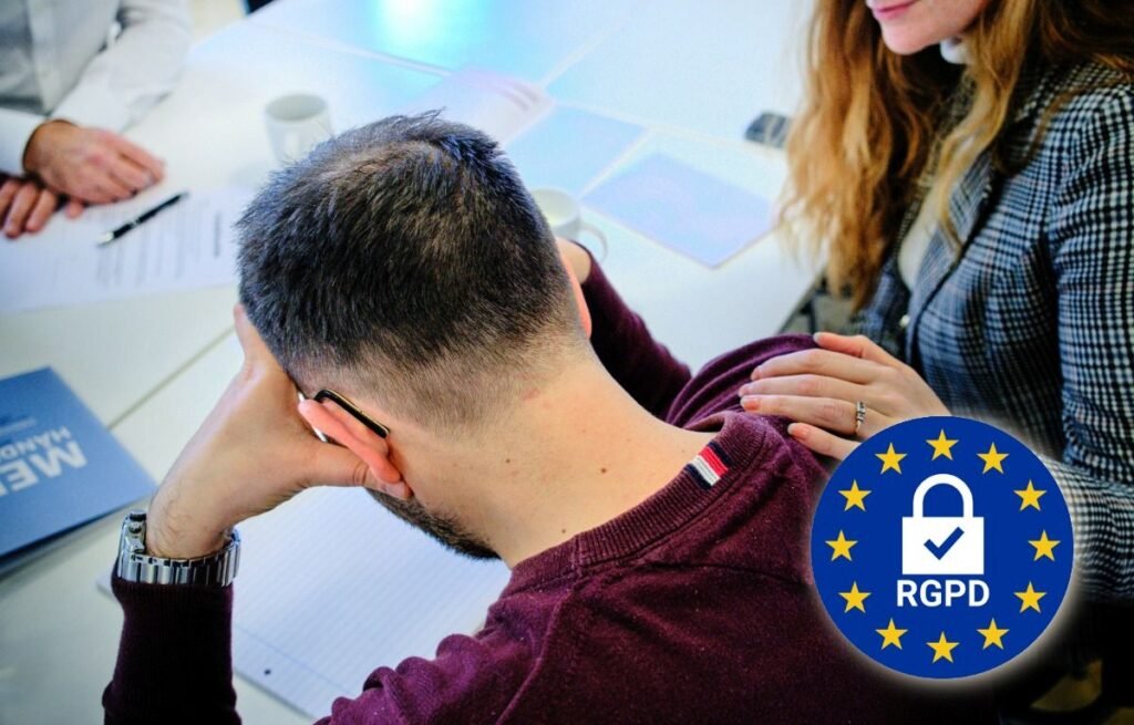 Homme assis à son bureau, tête entre les mains, soutenu par une femme posant la main sur son épaule, scène de stress professionnel